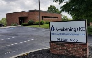 Awakenings KC Clinical Neuroscience Institute brick building exterior with monument sign displaying phone number 913-381-8555