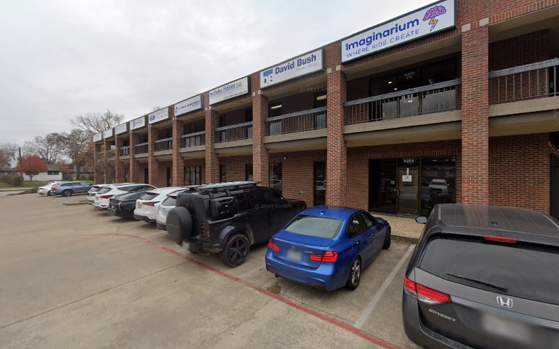 Brick medical building with parked cars and storefronts including Imaginarium