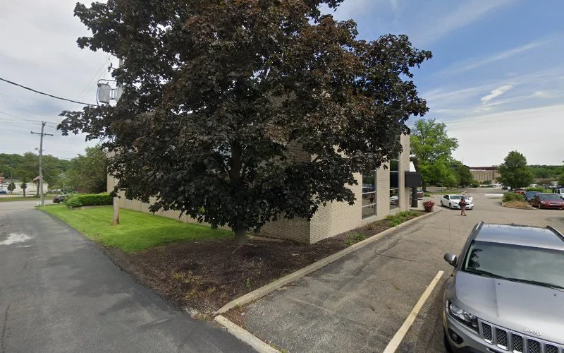 Signature Psychiatry Associates brick building exterior with large tree and parking lot