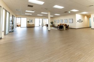 Spacious Relief Mental Health clinic interior with reception desk, seating areas, framed brain artwork on walls, and glass entry doors