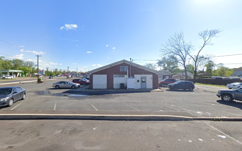 Red brick medical building with white trim and parking lot in daytime setting