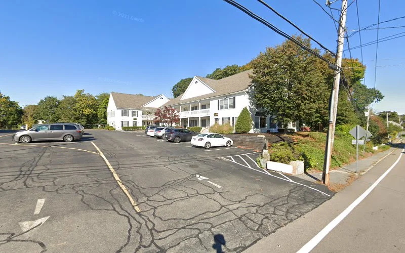 White two-story medical office building with parking lot and landscaping