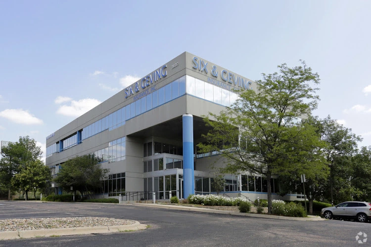 Modern medical building with glass windows and blue columns displaying Southern Colorado TMS and Dental signage