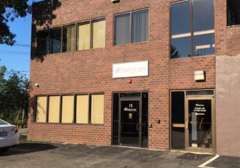 Red brick medical office building with yellow-trimmed windows and black entrance door