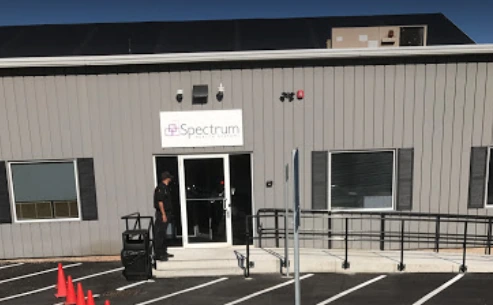 Spectrum Health Systems entrance, a metal-sided building with glass doors and accessibility ramp