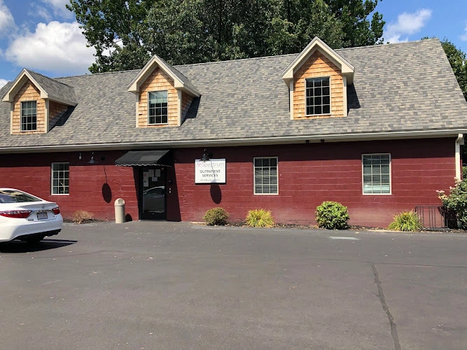 Red barn-style building with tan dormers, black door, and Spectrum Health Systems sign