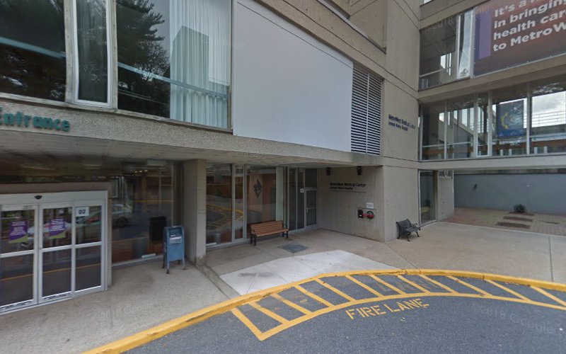 Modern clinical building entrance with glass doors and yellow fire lane marking