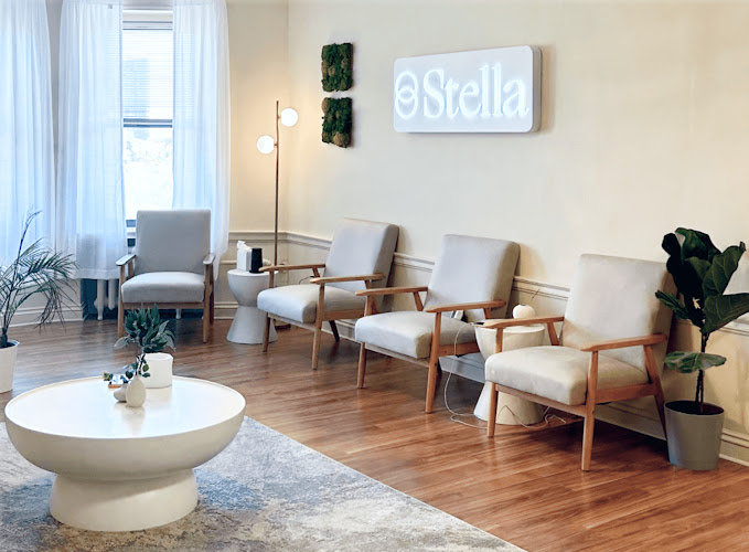 Stella Center waiting room with modern furniture, plants, and illuminated Stella signage