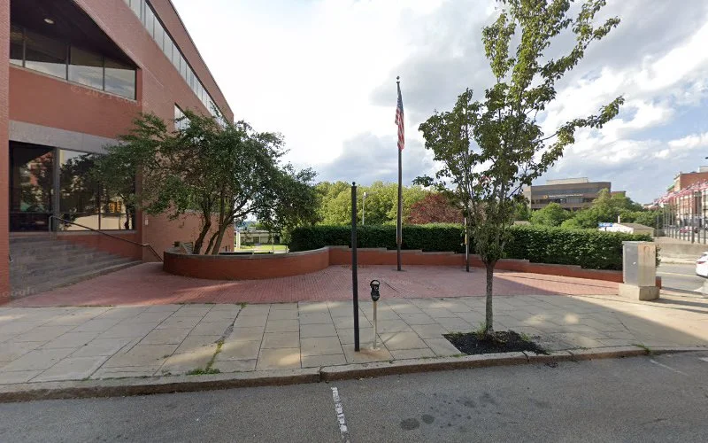 Brick courtyard with flagpole, trees, and brick building exterior