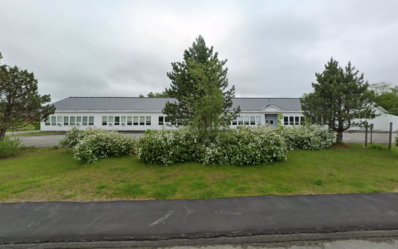 Sweetser Belfast campus, a single-story white building with gray roof surrounded by landscaping and green lawn