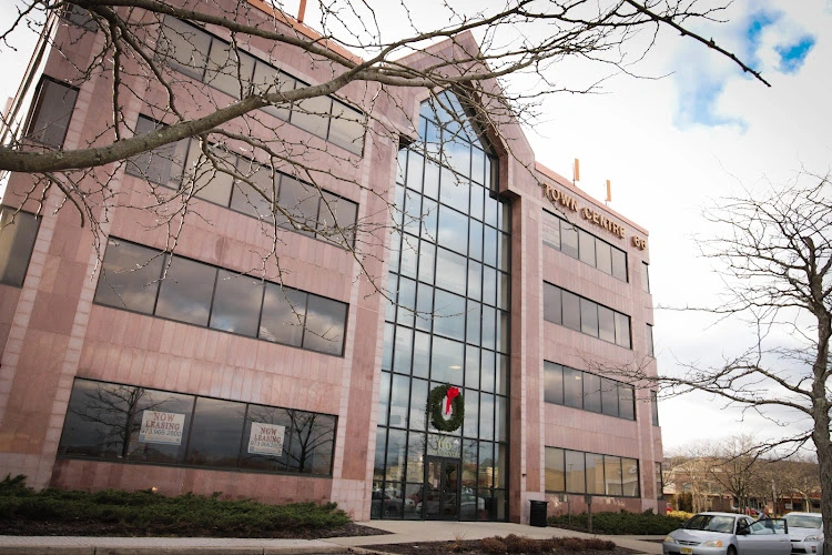 Red brick office building with large windows and wreath on entrance door