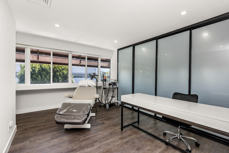 Modern therapy treatment room with TMS equipment and white desk