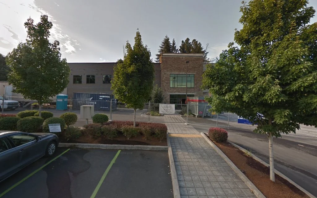 TMS NW clinic storefront with "Transcranial Magnetic Stimulation" signage and glass doors