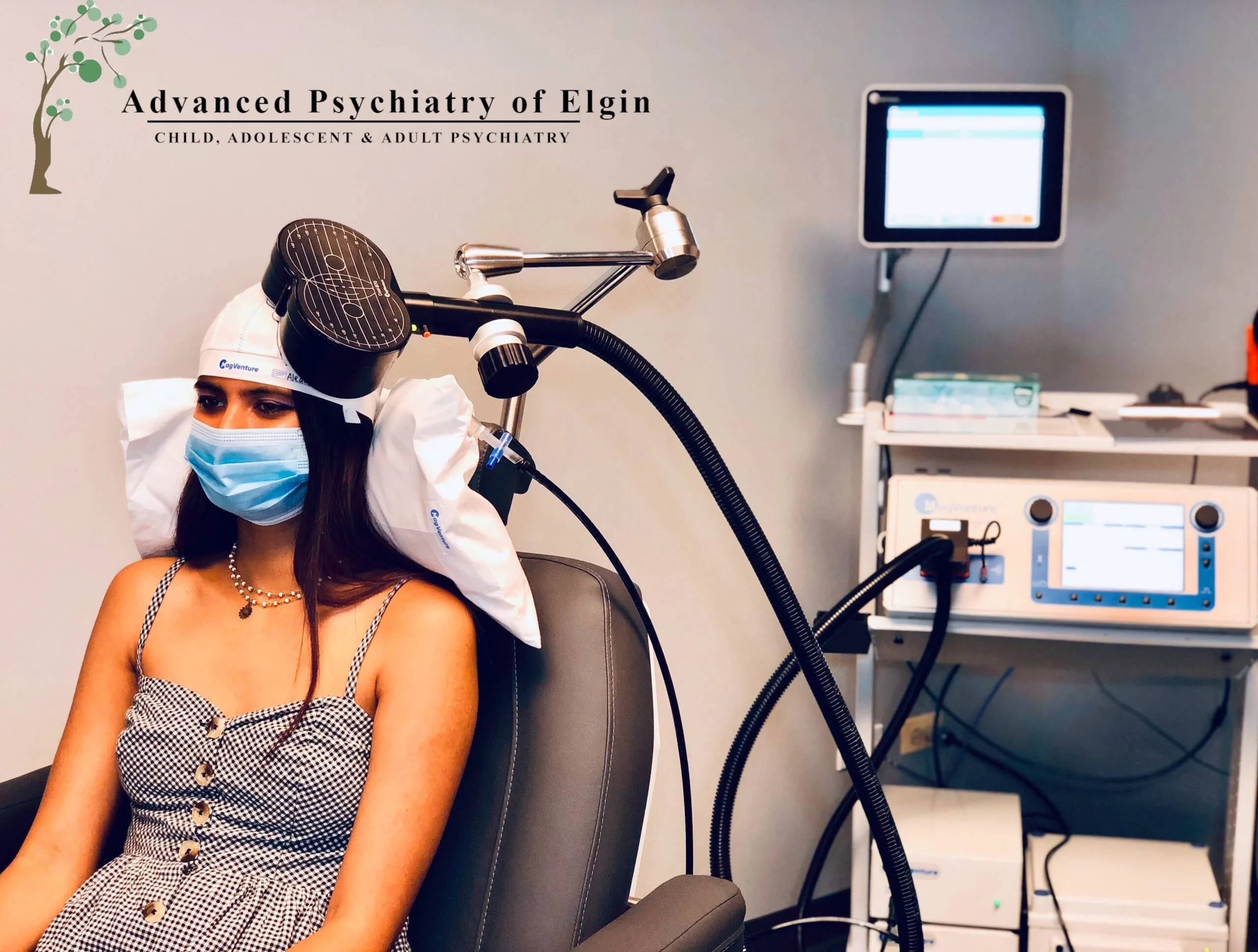 Patient undergoing TMS treatment with white helmet apparatus at Advanced Psychiatry of Elgin clinic