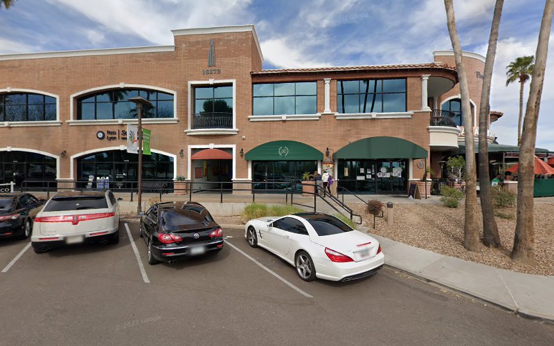 TMS Wellness Centers brick building exterior with palm trees and parked cars
