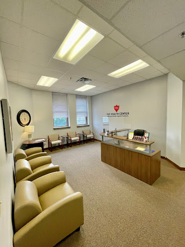 Top Health Center waiting room with yellow chairs, wooden reception desk, and windows