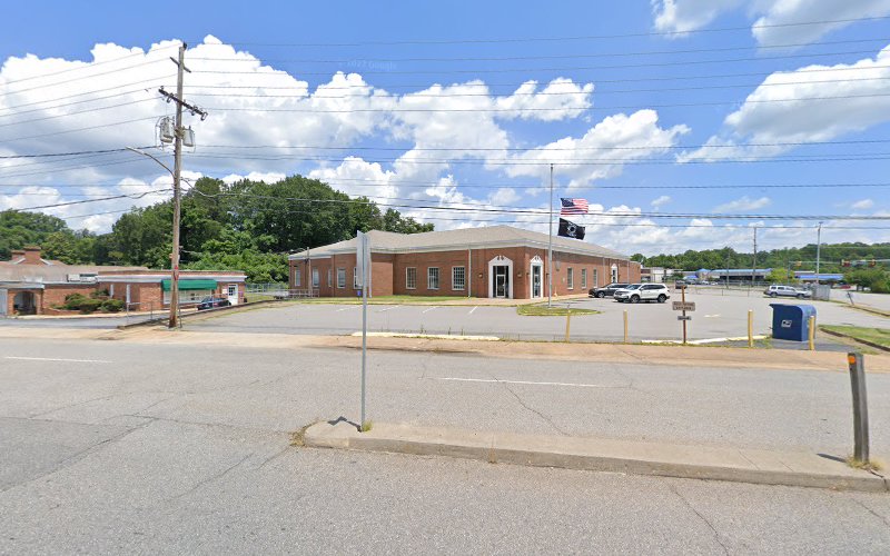 Triad Psychiatric & Counseling Center brick building exterior with parking lot and flags