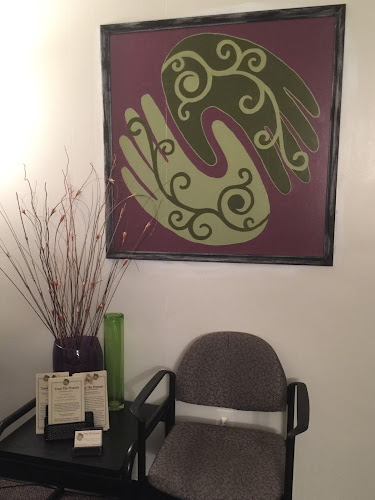 Decorative brain artwork on purple background hanging above waiting room chair