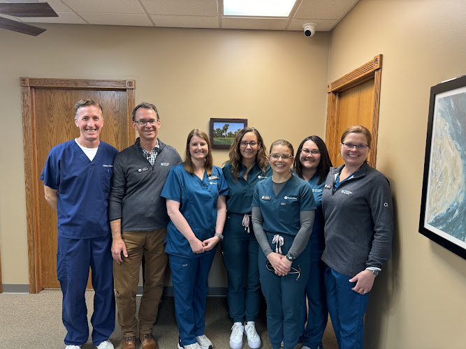 Eight mental health professionals standing together in a clinical office setting
