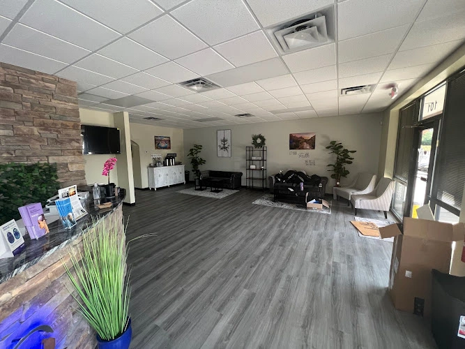 Welcoming mental health clinic reception area with brick accent wall, seating, plants, and informational materials