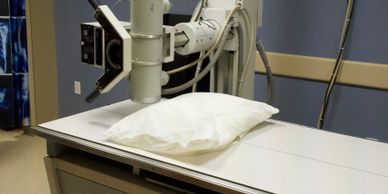 Medical imaging equipment with white positioning pad in clinical examination room