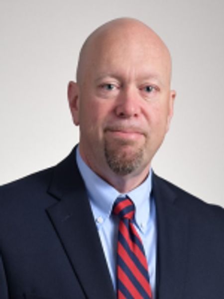 Man in dark business suit and red striped tie in professional headshot
