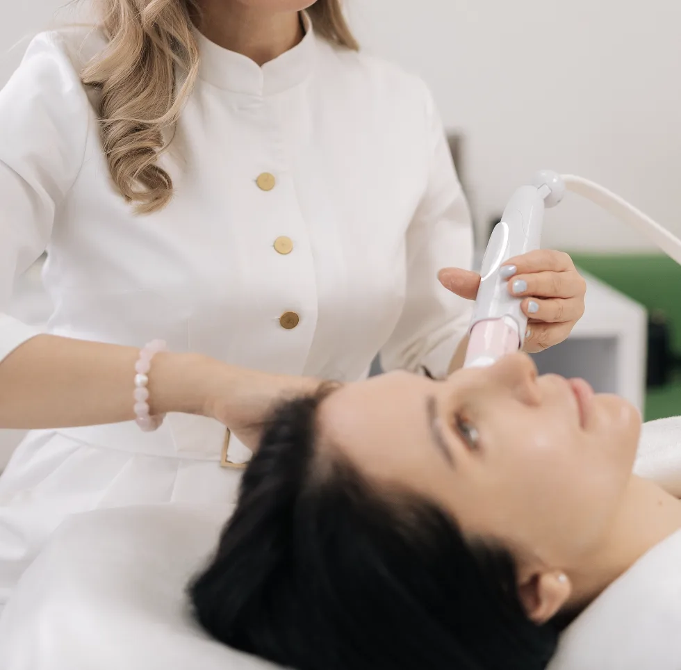 Clinician performing sublative rejuvenation treatment on a patient's face with handheld laser device