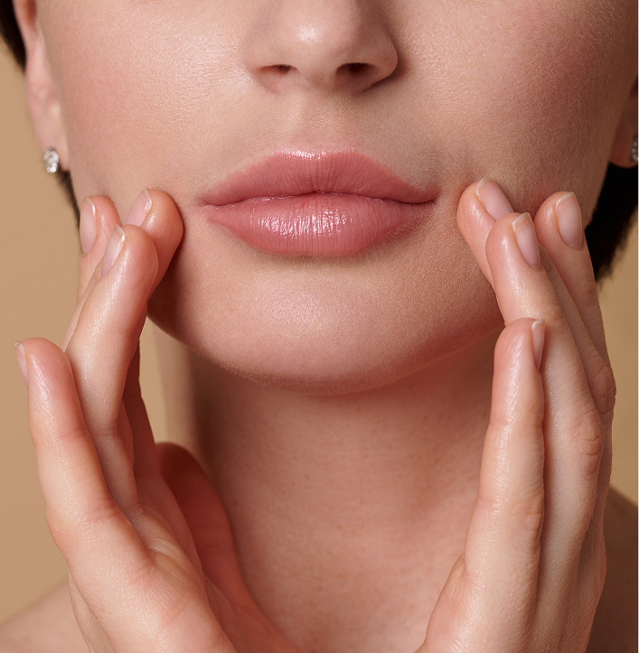 Woman's lower face and mouth area with hands framing the lips