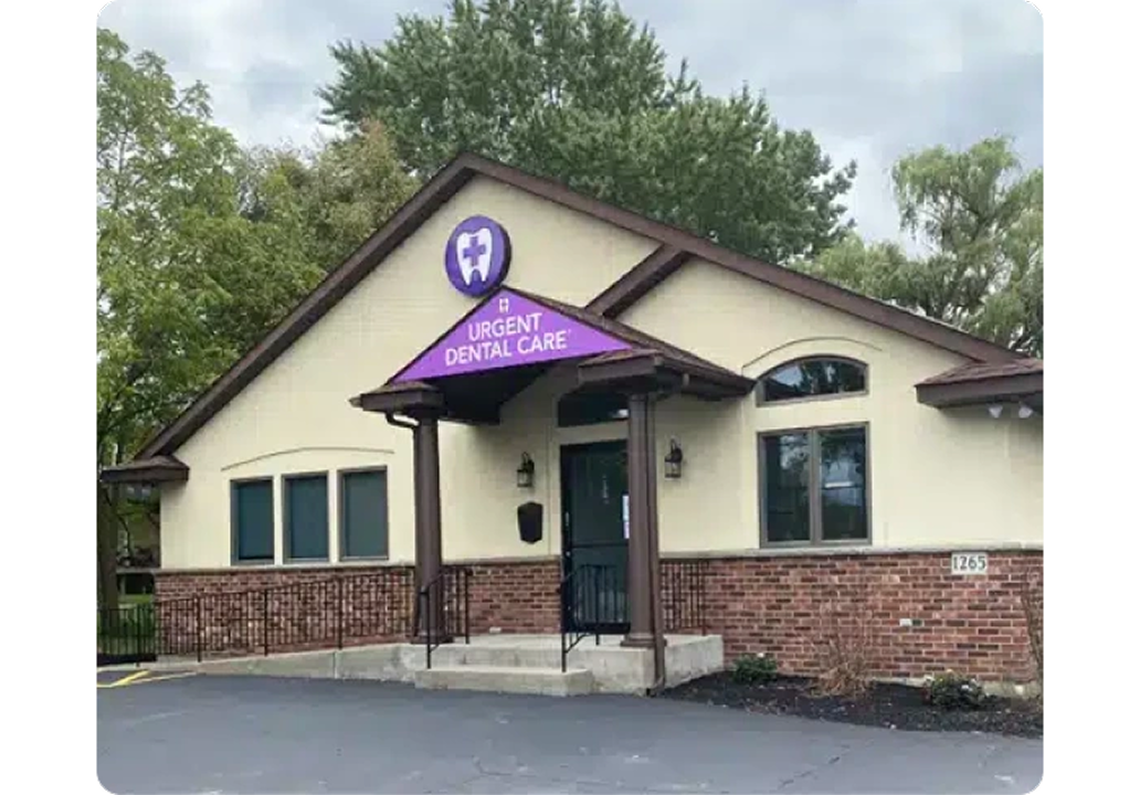Single-story cream and brick dental office with purple Urgent Dental Care awning over entrance