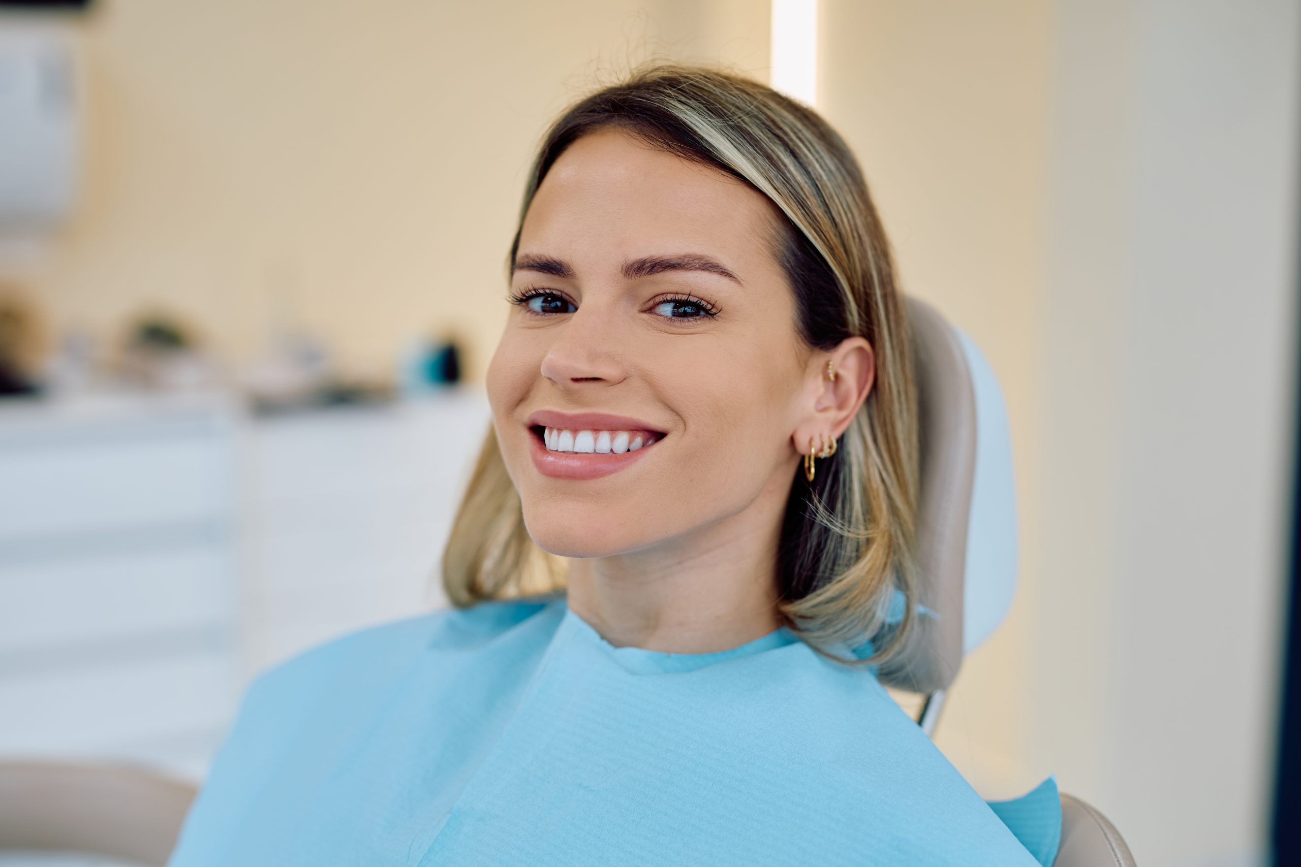 Patient smiling in dental chair during treatment at dental office