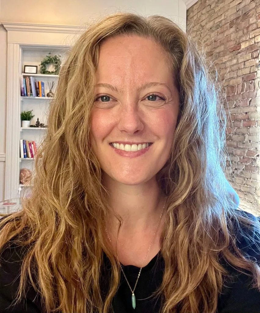 Arianne Johnston, therapist at Vibrant Life Therapy, smiling at the camera in a professional office setting