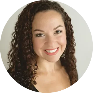 Woman with curly brown hair smiling at camera