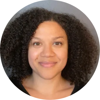 Woman with dark curly hair smiling at camera