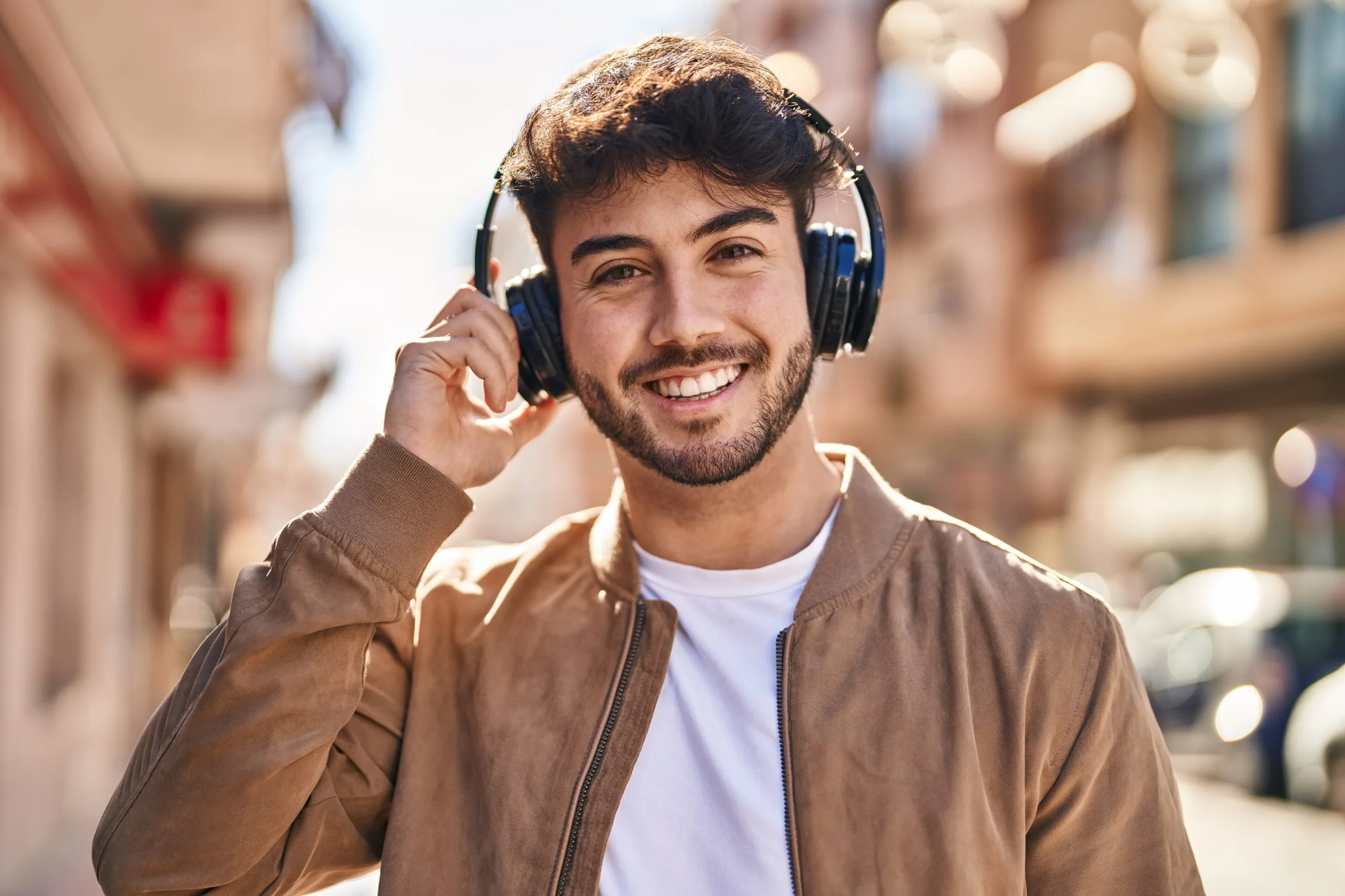 Young Hispanic man smiling while listening to music on a street – SPRAVATO treatment in Concord, CA