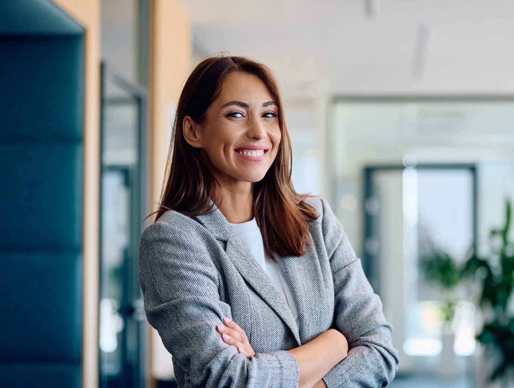 Young businesswoman with arms crossed standing in an office – psychiatrist in Lafayette, CA