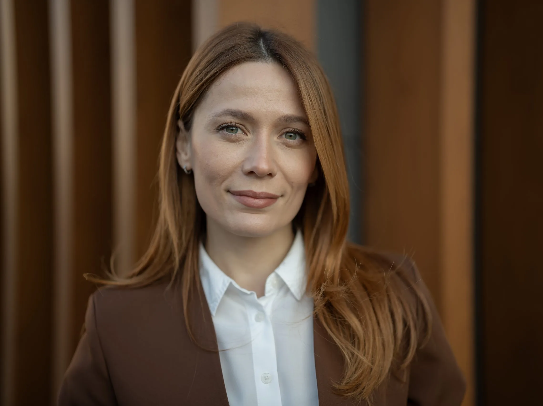 Young professional woman with red hair standing confidently – psychiatric care patient