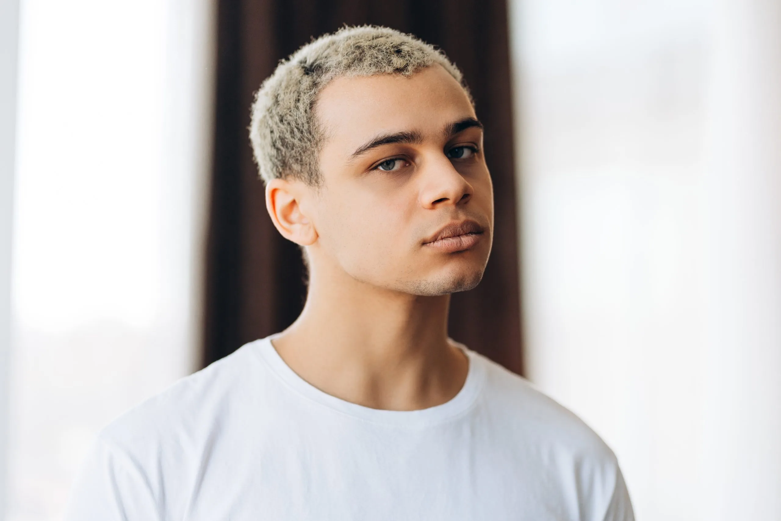 Serious Hispanic man with a stylish hairstyle looking at the camera – mood disorder treatment patient
