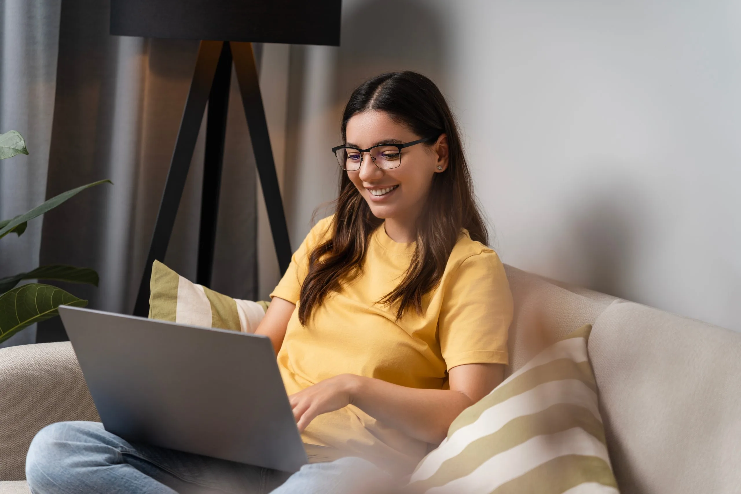 Woman smiling during an online therapy session on her laptop at home