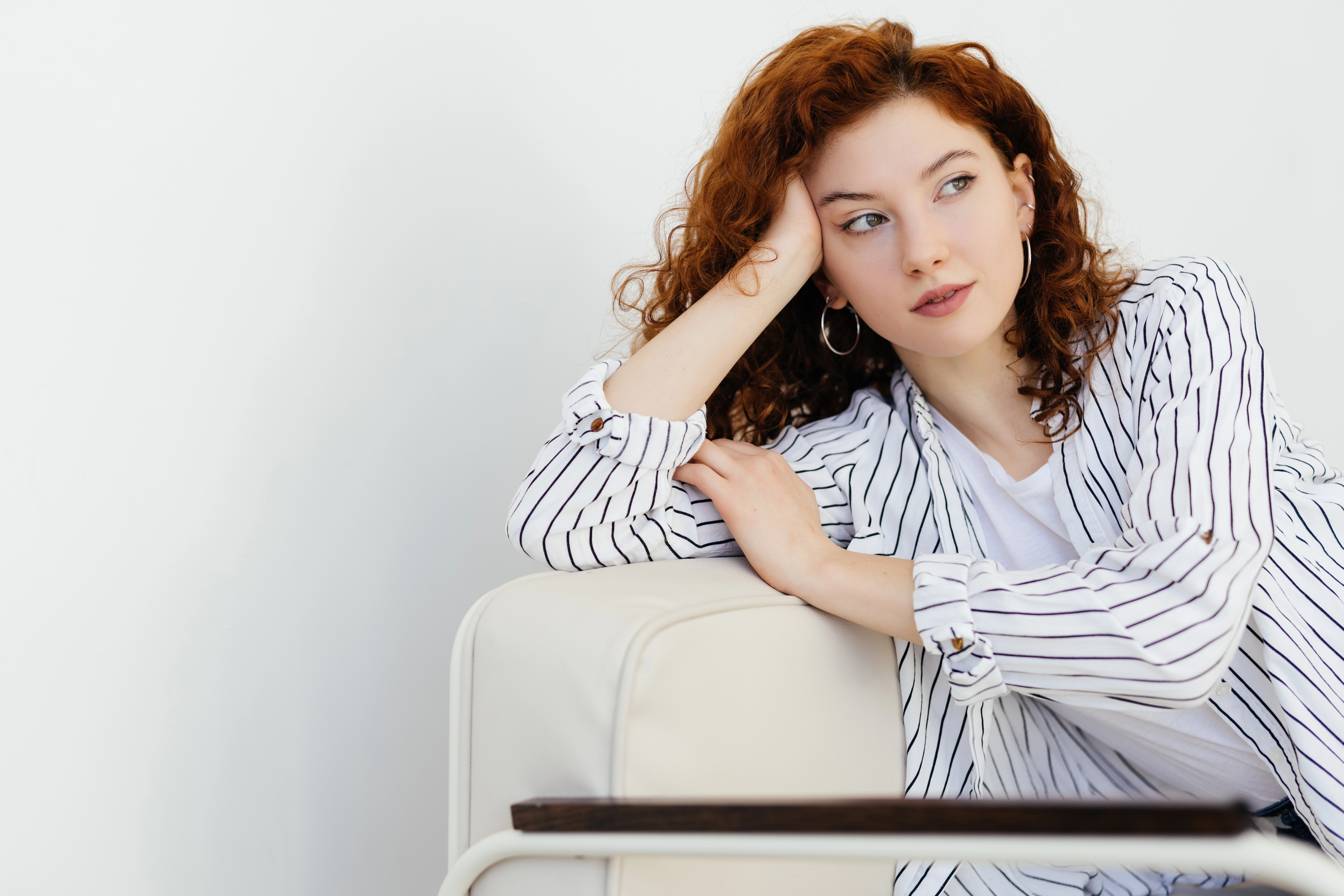 Red-haired woman sitting on a couch in a living room