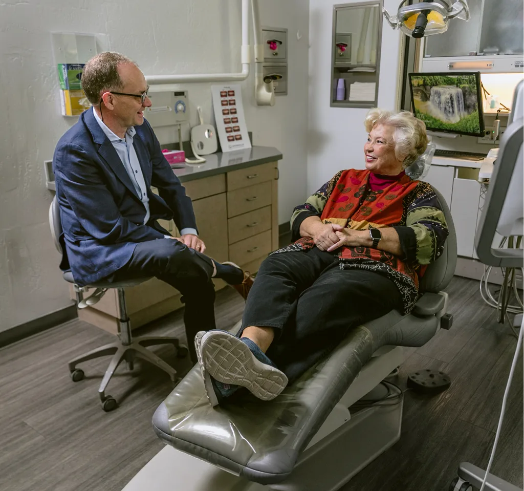 Dentist speaking with patient in treatment room during consultation