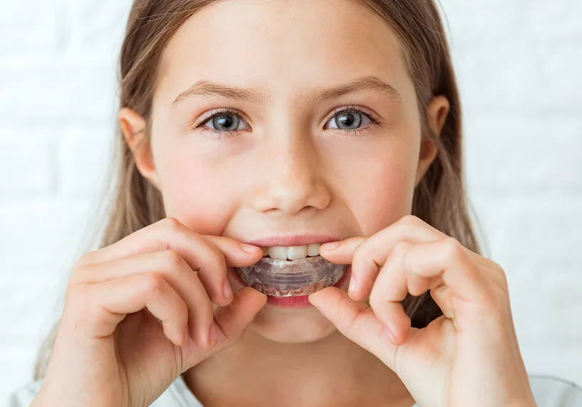 Child inserting a MyoBrace oral appliance into their mouth