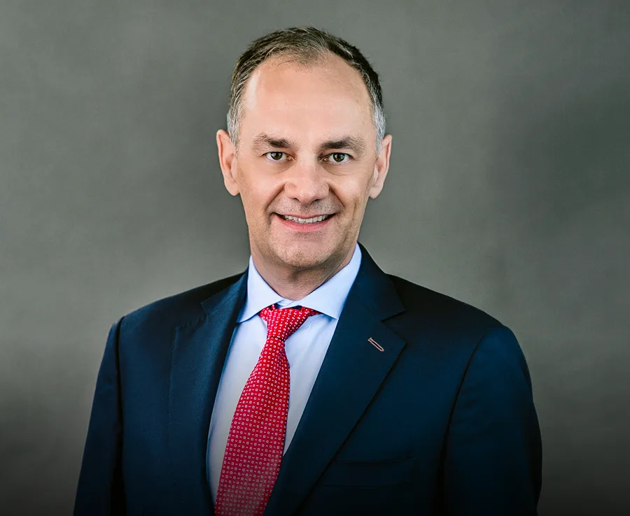 Professional headshot of male dentist in navy blazer and red tie
