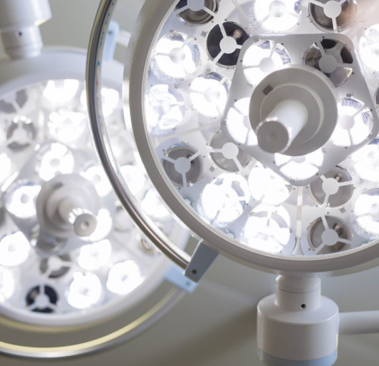 Close-up of multiple surgical lights with white LED rings and metal fixtures