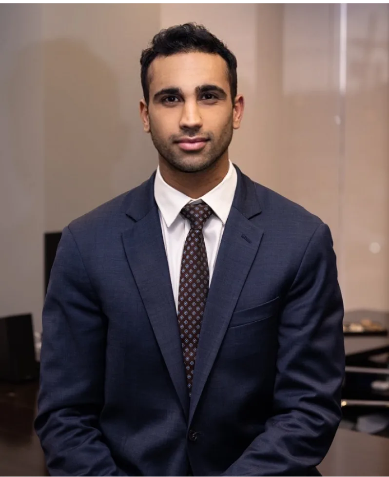 Man in dark navy suit and burgundy tie, professional office headshot