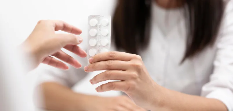 Person holding blister pack of medication tablets