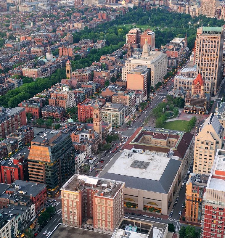 Aerial view of urban neighborhood with brick buildings, green trees, and streets