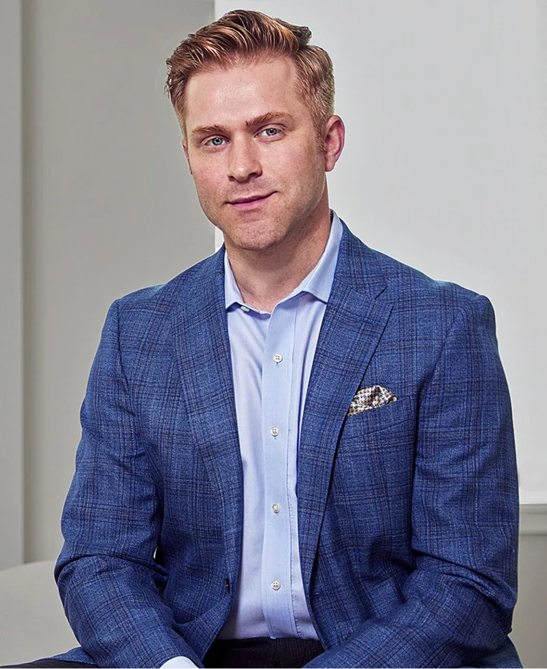 Professional man in blue blazer and light blue shirt against neutral background