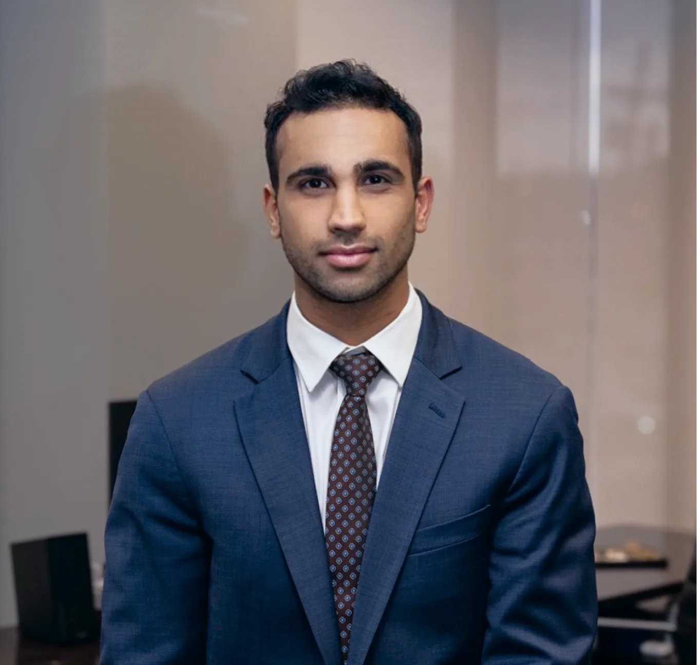 Man in dark navy suit and burgundy tie, professional headshot