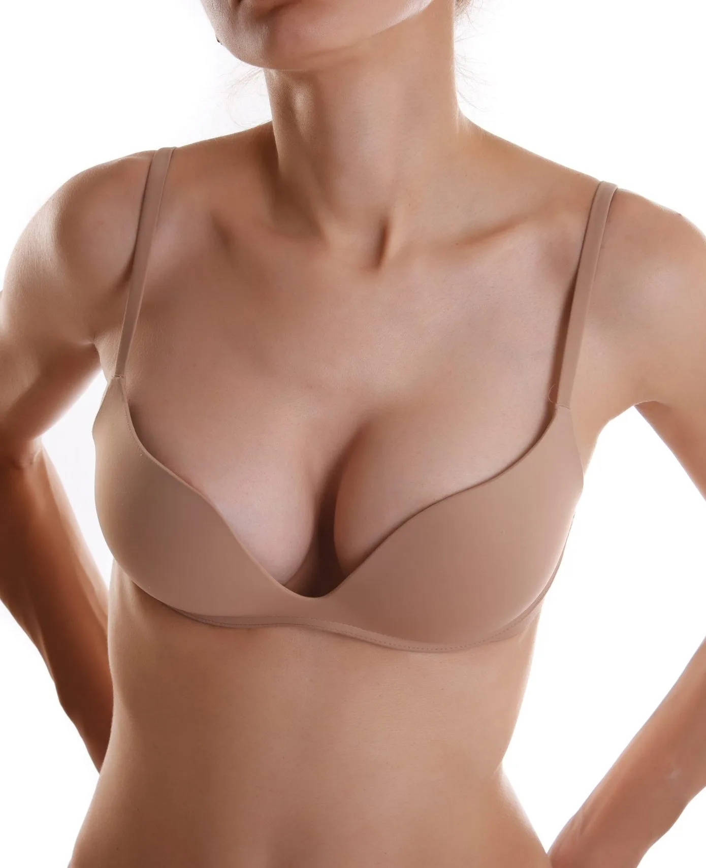 Close-up of woman's torso wearing beige bra against white background