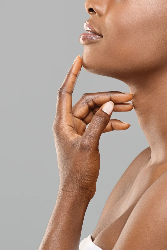 Woman touching her chin and neck area in profile view